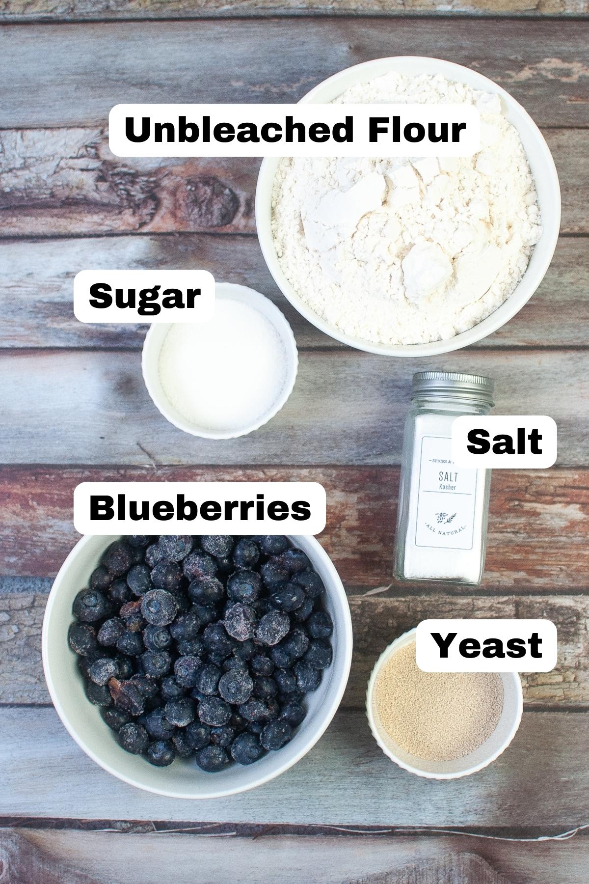 ingredients for air fryer bagels including flour, sugar, salt, frozen blueberries and yeast