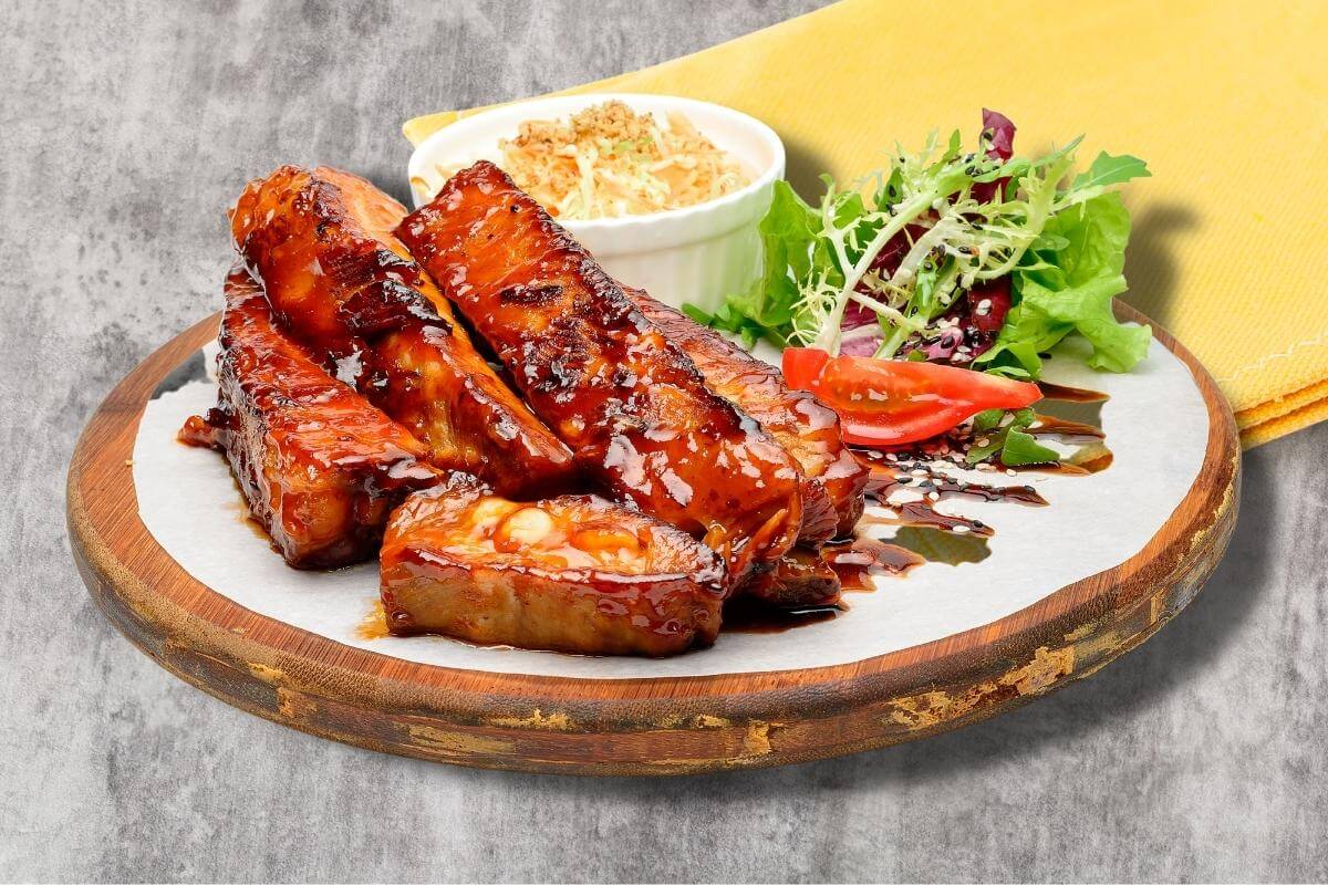 air fryer country style pork ribs on a rustic round board with side dishes
