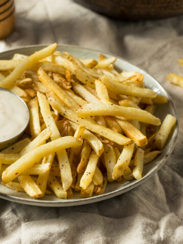 air fryer frozen French fries with ranch dressing on a blue stone plater