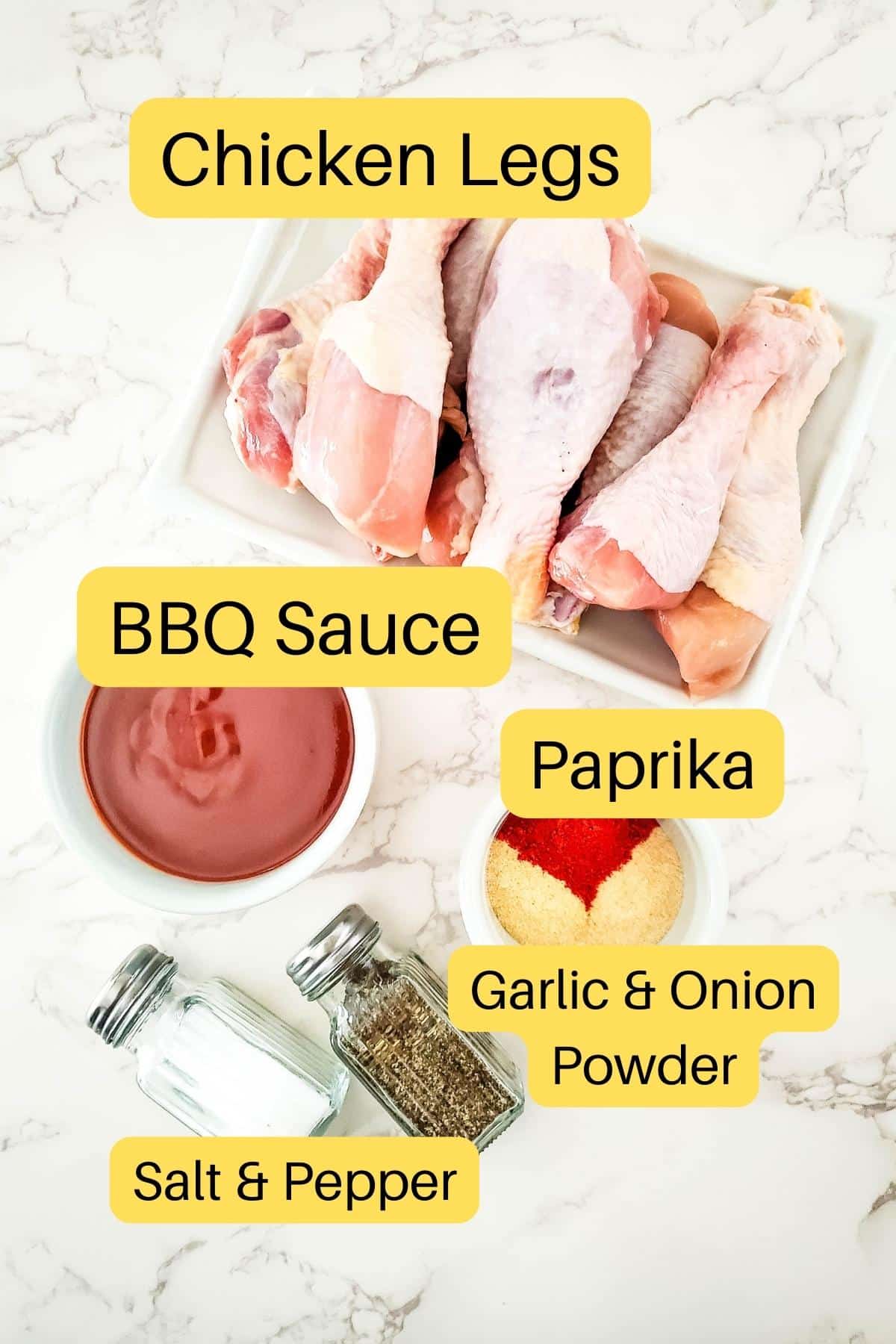 BBQ chicken leg ingredients showing a plate of chicken wings, a bowl of bbq sauce, paprika, garlic powder, onion powder, salt and pepper.