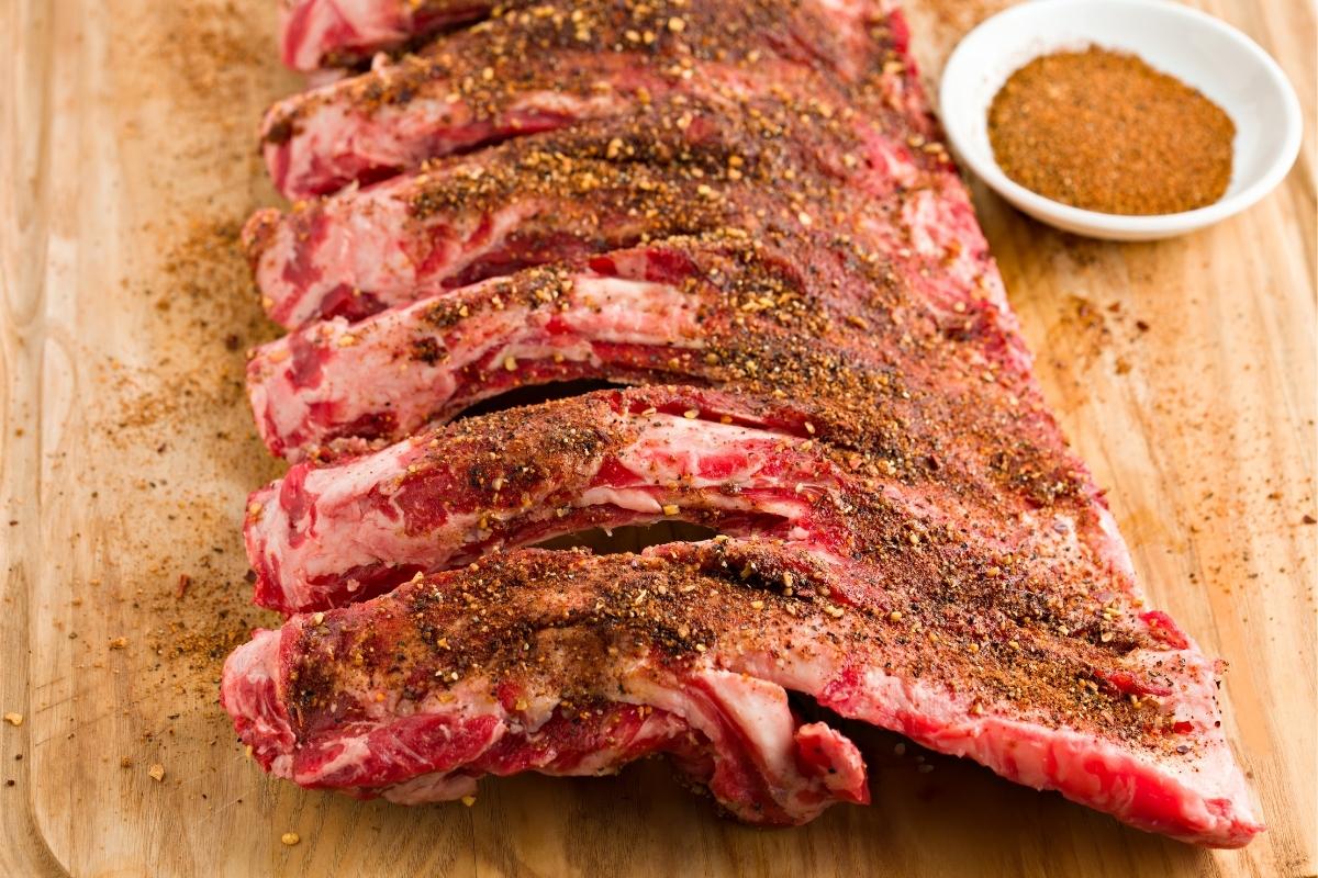 slab of ribs on a carving board with dry rub for ribs