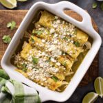 Enchiladas Verdes top view baked in casserole dish sprinkled with Cotija