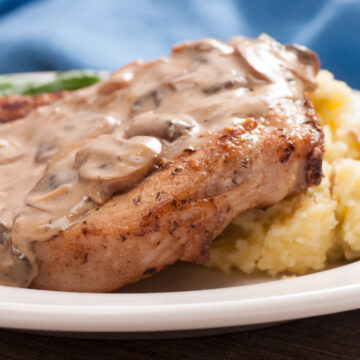 close up of pork chops with cream of mushroom arranged on mashed potatoes