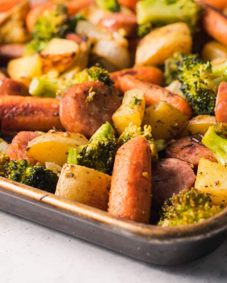 sheet pan with sausage, potatoes, carrots, and broccoli all nicely roasted