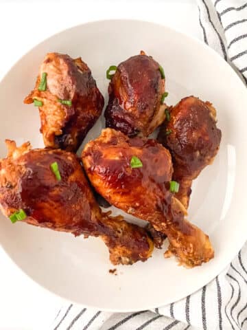 Slow cooker bbq chicken legs on a white plate.