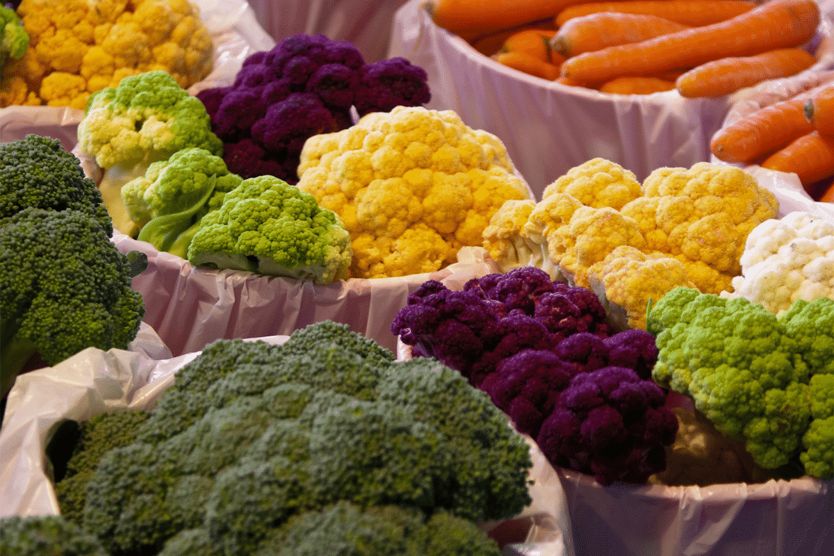 different colored cauliflower arrange at the grocery store. a colorful option for veggie trays